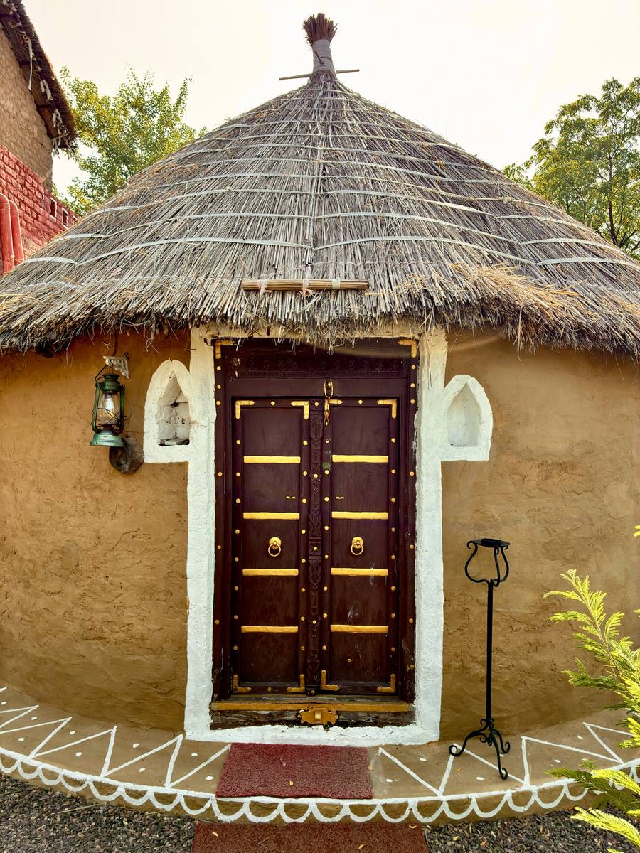 Cottage with carved wooden door and thatched roof